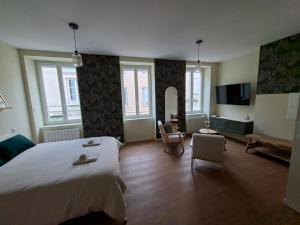 a bedroom with a large bed and a living room at Le Ségusiave SPA in Feurs
