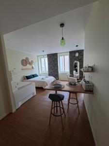 a bedroom with a bed and a table in a room at Le Ségusiave SPA in Feurs