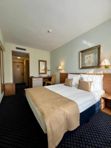 ein Hotelzimmer mit einem großen weißen Bett darin in der Unterkunft Hotel Monogram Park in Ruma + 143 Fotos