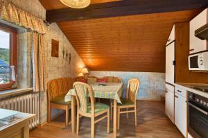 a kitchen with a table and chairs in a room at Ferienwohnung Uhrmann Franz in Lindberg +13 photos