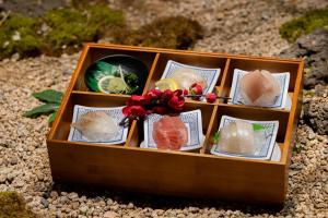 a wooden box filled with sushi on top of rocks at Mandeok Denbasta Ryokan in Busan