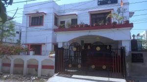 a white building with a gate in front of it at THUBE Saheb B&B in Jabalpur