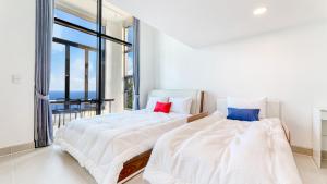 two beds in a bedroom with a large window at Goseong Belossi Ayajin Kids Poolvilla in Goseong