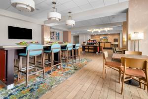 a lobby with a bar and chairs and a waiting room at Hampton Inn Marion in Marion