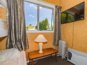 a bedroom with a bed and a window at Sweet Rangataua - Rangataua Bach in Ohakune