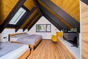 a bedroom with two beds and a flat screen tv at Apartmány U Kovárny in Horní Blatná