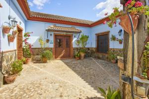 a courtyard of a house with a door and flowers at Casa Sofia in Ubrique