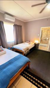 a bedroom with two beds and a window at Pangolin self-catering accommodation in Windhoek