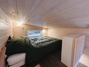 a small bed in a small room with a wooden ceiling at Tiny House im Almtal in Pettenbach +14 photos