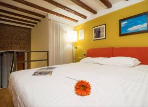 ミラノにあるRomantic Apartment Porta Veneziaのベッドルーム1室(花のついたベッド1台付)