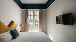 a bedroom with a bed and a tv on the wall at THE FOLK in Yogyakarta