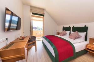 a hotel room with a bed and a desk and a desk at Genuss-Pension Herti in Übelbach