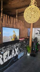 a room with a flat screen tv on a wall at Secret Surf Hostel in Weligama