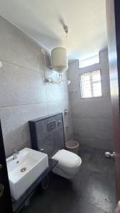 a bathroom with a white toilet and a sink at Lavish Hotel BG-Lodge in Bangalore +16 photos