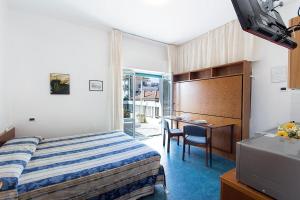 a hotel room with a bed and a desk at Casavacanze Internazionale in Diano Marina