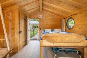 a bedroom with a bed in a wooden cabin at Tiny Water Villa on a Lake with shared camping bathroom in Zweisimmen +16 photos