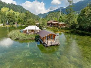 an island in the middle of a river with houses at Tiny Water Villa on a Lake with shared camping bathroom in Zweisimmen