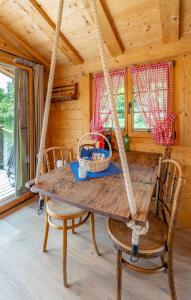 a swing in a cabin with a table and chairs at Tiny Water Villa on a Lake with shared camping bathroom in Zweisimmen