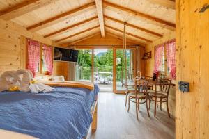 a bedroom with a bed and a table and chairs at Tiny Water Villa on a Lake with shared camping bathroom in Zweisimmen