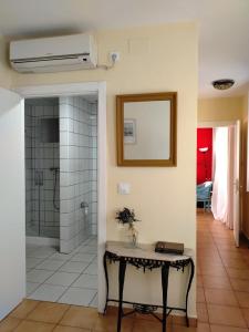 a bathroom with a shower and a table with a mirror at Apartamento Rural la Fontanina TRCC0087 Complejo la Fontanina in Mata de Alcántara +23 photos