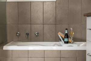a bath tub with a bottle of wine and a glass at Wallace Cottage in Mount Gambier +28 photos