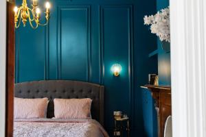 a bedroom with blue walls and a bed with pink pillows at Wallace Cottage in Mount Gambier