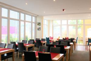 a dining room with tables and chairs and windows at Come IN Hotel in Ingolstadt