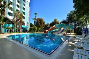 a swimming pool with a slide in a building at Ananas Hotel in Alanya