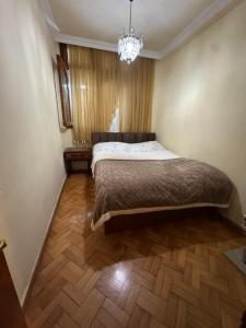 a bedroom with a bed and a chandelier at Apartment old Batumi in Batumi