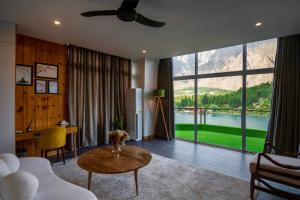 a living room with a table and a large window at Tibet Hotel in Skardu