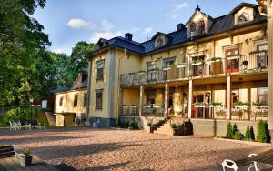 a large building with a courtyard in front of it at Hennickehammars Herrgård in Filipstad