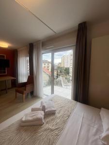 a bedroom with a bed and a large window at Appart One Chambéry in Chambéry