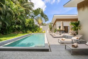 a swimming pool with lounge chairs and a villa at VILLA LOUMA - 4 Bedrooms with Private Pool in Koh Samui