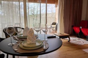 a dining room table with wine glasses at Echappée Nocturne in Saint-Privat
