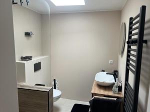 a white bathroom with a sink and a toilet at NEU! Dat Lütt Hüs in Tönning