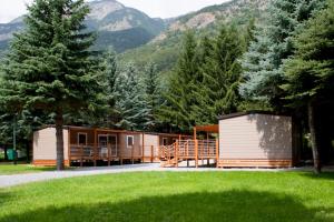 Gran Bosco Camping & Lodge في Salbertrand: كابينة في وسط ميدان فيه اشجار