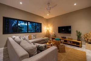 a living room with a couch and a tv at VILLA LOUMA - 4 Bedrooms with Private Pool in Koh Samui