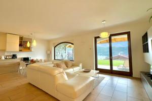 a living room with a white couch and a kitchen at Villa Aurelia in Plesio