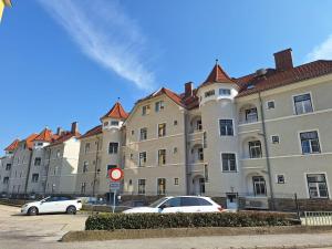 two cars parked in front of a large building at Krems am Campus in Krems an der Donau