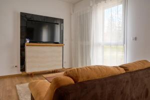 a living room with a couch and a flat screen tv at Echappée Nocturne in Saint-Privat