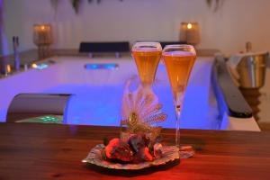 two champagne glasses sitting on a table in front of a pool at Echappée Nocturne in Saint-Privat +11 photos