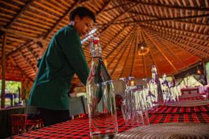 a woman standing in front of a table with wine glasses at Kutoka Lodge in Arusha +247 photos
