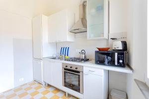 a white kitchen with white cabinets and a microwave at InnPisaRentals2- Casa dei Cavalieri in Pisa