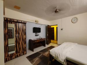 a bedroom with a bed and a tv on the wall at Hotel The Star in Kālundri