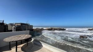 a balcony with a table and a view of the ocean at Riad d'exception vue mer au coeur de la médina Essaouira - Mandji Dream in Essaouira