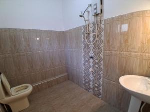 a bathroom with a shower and a toilet and a sink at Sasagara Beach Villa in Tangalle +53 photos