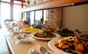 uma linha de buffet com pratos de comida numa mesa em Hai Yuansu 178 em Yanliau