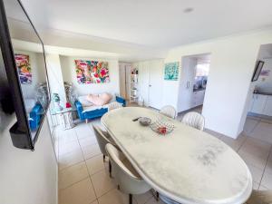 a dining room with a white table and chairs at Vista Air conditioned Holiday Dream Castle Youth Hotel in Brisbane