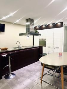 a kitchen with a table and a sink at Casa con piscina ideal vacaciones en la playa in Comarruga