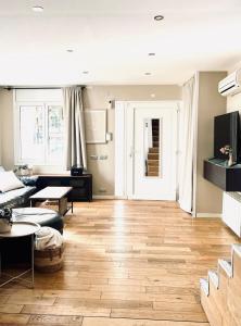 a living room with a couch and a wooden floor at Casa con piscina ideal vacaciones en la playa in Comarruga +21 photos